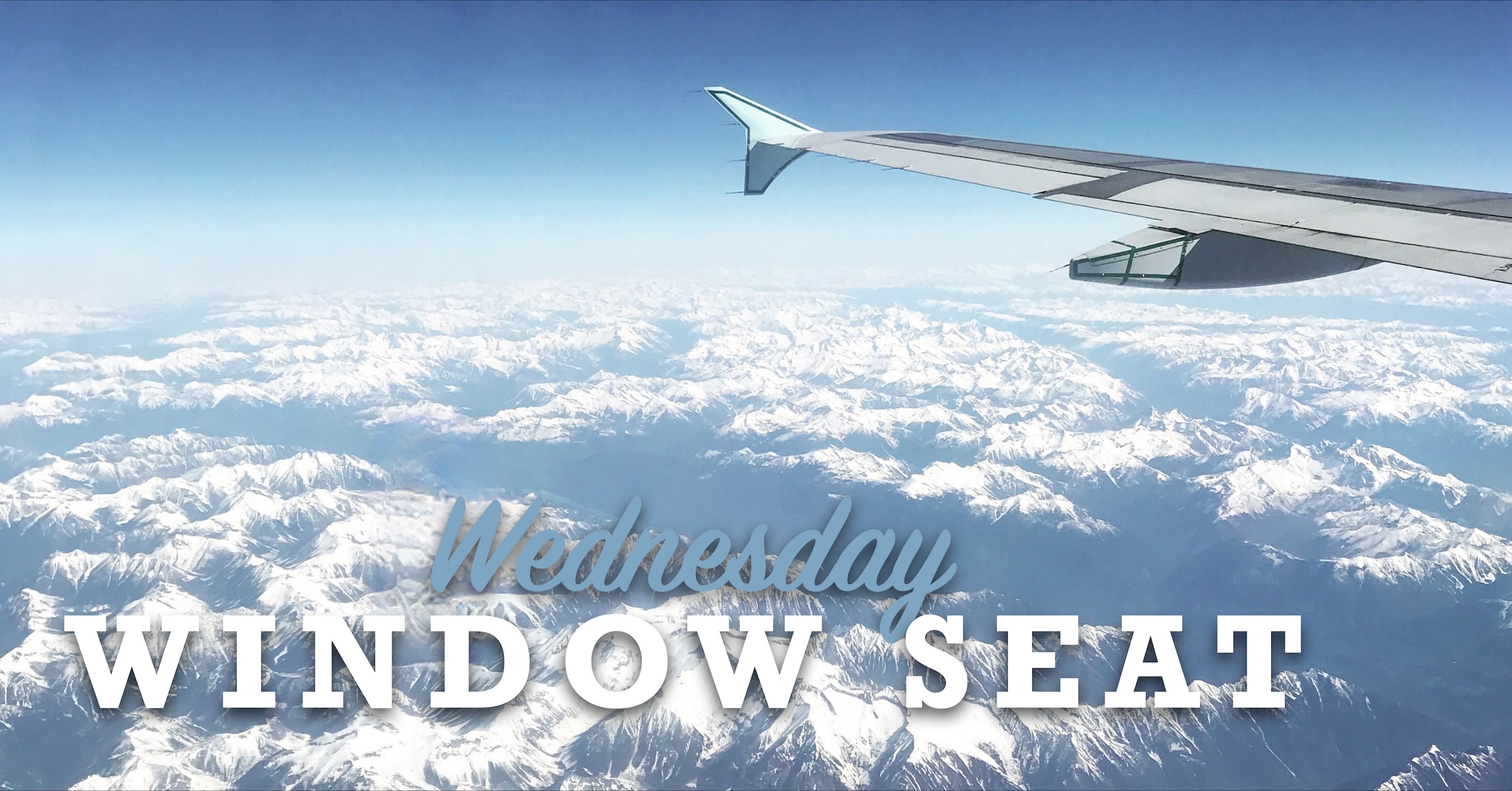 The wing of a passenger aircraft taken from a passenger window.  A winglet can be seen at the end of the wing. The aircraft is flying over snow-capped mountains under a cloudless blue sky which we subsequently identified from photo metadata as ‎⁨Goat Range Provincial Park⁩,  ⁨British Columbia⁩, ⁨Canada⁩. Superimposed over the image are the words 'Wednesday', in bluish script, and then 'WINDOW SEAT' in larger, white, block letters.