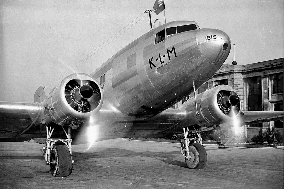 A DC-3 from the front, framing the two engines and the forward part of the fuselage. The word 'IBIS' is painted on the nose.