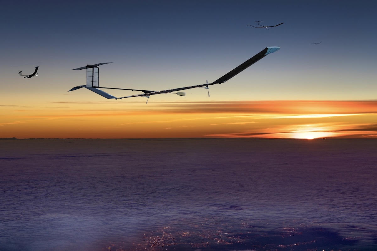 A number of Airbus/AALTO Zephyrs fly at high altitude in a clear blue sky at either sunrise or sunset. City lights are visible below.