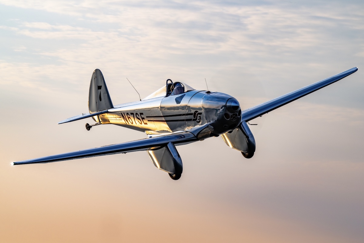 The Spirit Engineering SE-1 low-wing, all-metal monoplane in flight, flying toward the camera in a clear sky during either sunrise or sunset.