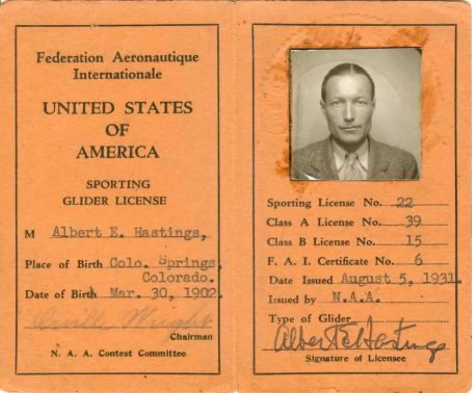 An antique document, orangy-brown in colour, with the words « Fédération Aeronautique Internationale ¶ UNITED STATES OF AMERICA ¶ SPORTING GLIDER LICENSE » along with all the particulars of the licensee, which in this case is « Albert E. Hastings ». It includes, on the right side of the frame, an image of the licensee. Notably, it is signed by Orville Wright, presumably of Wright Brothers fame. Original caption from source: « Al Hasting’s glider license from 1931. » (📸 ©2025 National Soaring Museum, all rights reserved.)