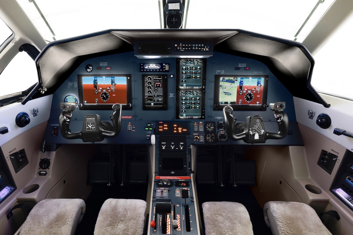 The distinctly uncluttered, all-glass instrument panel of a Pilatus PC-12. The displays are lit up and displaying essential flight data.