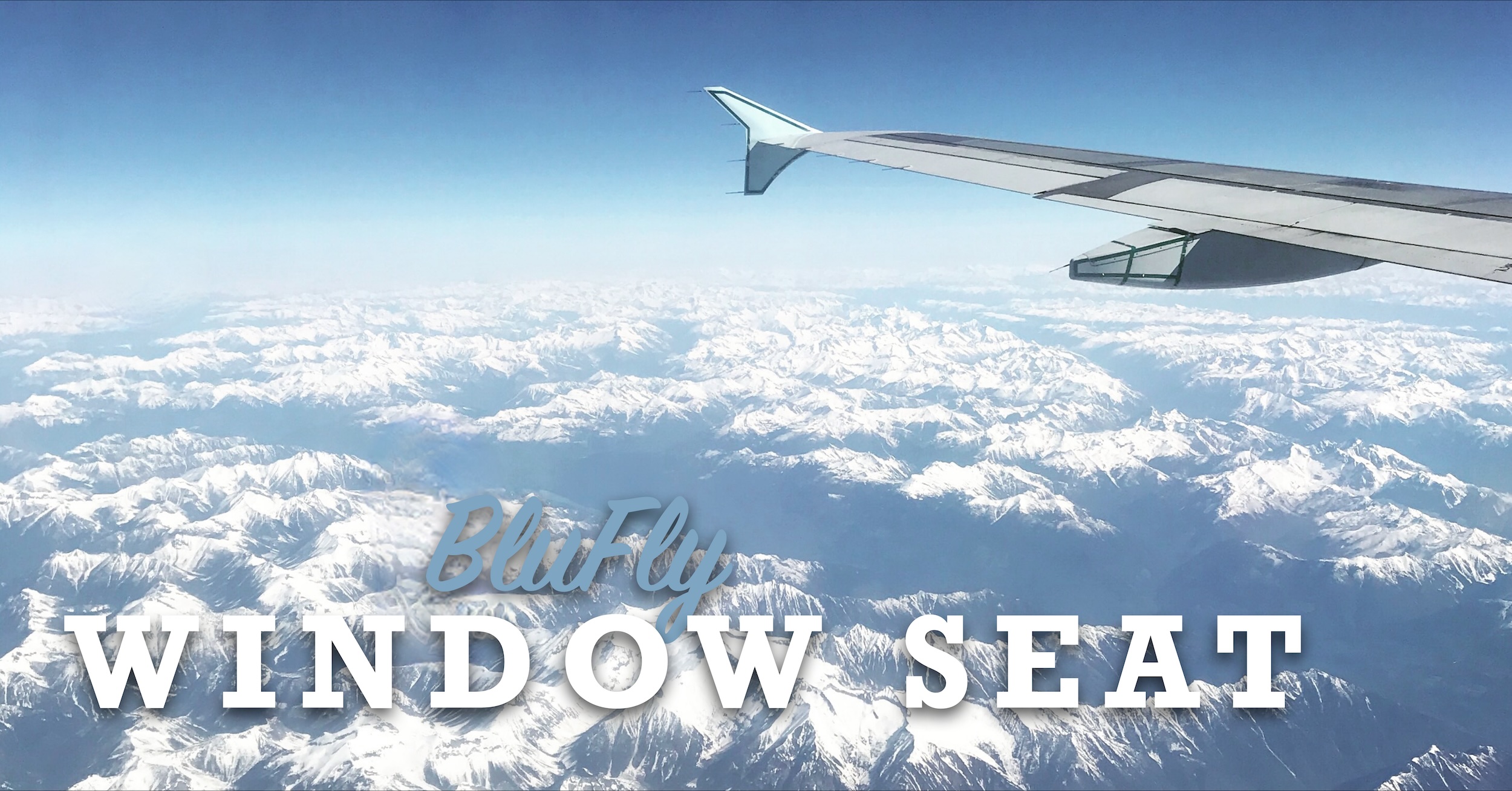 The wing of a passenger aircraft taken from a passenger window.  A winglet can be seen at the end of the wing. The aircraft is flying over snow-capped mountains under a cloudless blue sky which we subsequently identified from photo metadata as ‎⁨Goat Range Provincial Park⁩,  ⁨British Columbia⁩, ⁨Canada⁩. Superimposed over the image are the words 'Wednesday', in bluish script, and then 'WINDOW SEAT' in larger, white, block letters.